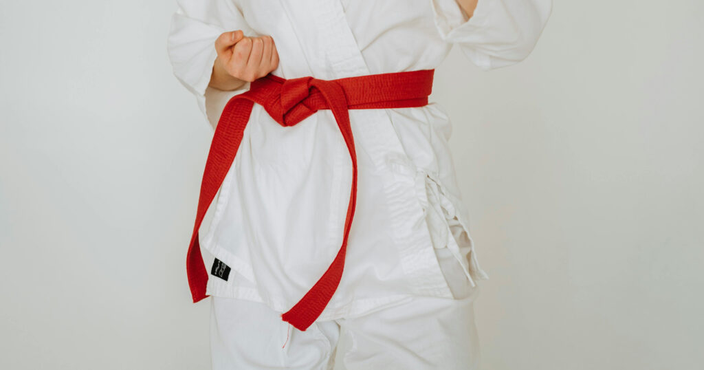 Cropped Photo of a person wearing a white tae kwon do uniform and a red belt